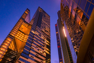 High-rise buildings in the city. Skyscrapers against the evening sky. Tall buildings with huge Windows. Offices in the city center. Modern urban architecture.