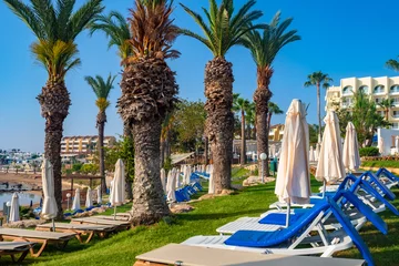 Poster Cyprus. Hotels near the coastline. Palm trees, sun loungers and umbrellas on the Mediterranean coast. Protaras. Pernera. The Beach Of Kalamies. Beach holidays on the Mediterranean coast. © Grispb