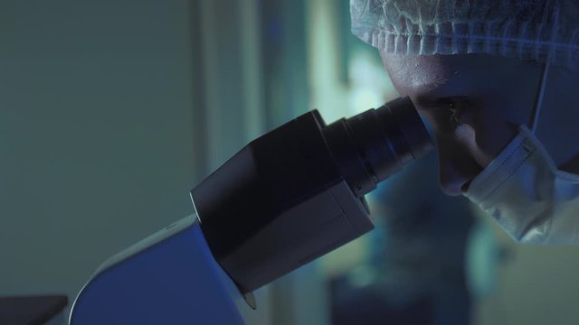 In a Modern Laboratory Scientist Conduct Experiments. The embryologist Examines Samples with a Microscope