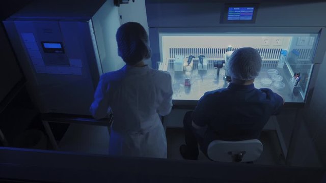 In a Modern Laboratory Scientist Conduct Experiments. Embryologist Examines Samples with a Microscope