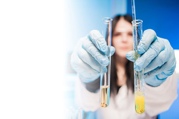 A woman holds two flasks in front of her. A chemist holds reagents in his hands. Flasks in the lab...