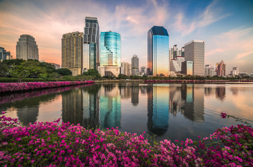 Lake with Purple Flowers in City Park under Skyscrapers at Sunset. Benjakiti Park in Bangkok, Thailand