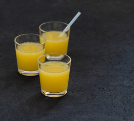 Orange juice in a glass on a dark background