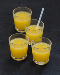 Orange drink in a glass on a dark gray background