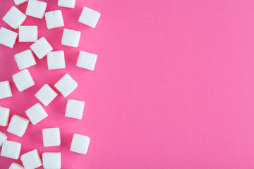 Fototapeta na wymiar sugar cubes on vivid pink background, flat layout, top view, copy space
