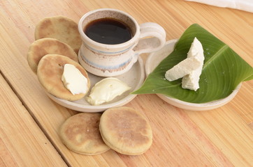 arepa de trigo venezolana con queso cuajado y taza de café caliente