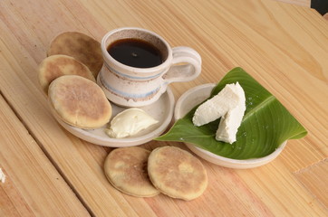 arepa de trigo venezolana con queso cuajado y taza de café caliente