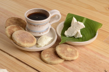 arepa de trigo venezolana con queso cuajado y taza de café caliente