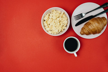 Top view of cup of coffee with flowers on red