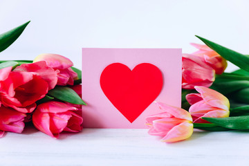 Fototapeta premium Greeting card and pink tulipp flowers on white background