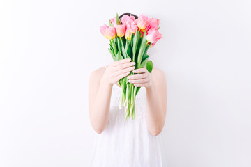 Woman holding a spring bouquet of pink tulips in her hands. Bunch of fresh tulip flowers in female hands