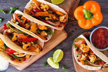 Grilled spicy cauliflower fajitas. Above view table scene over a wood background. Healthy eating,...