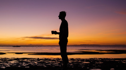 Fototapeta na wymiar silhouette of a woman on the beach at sunset