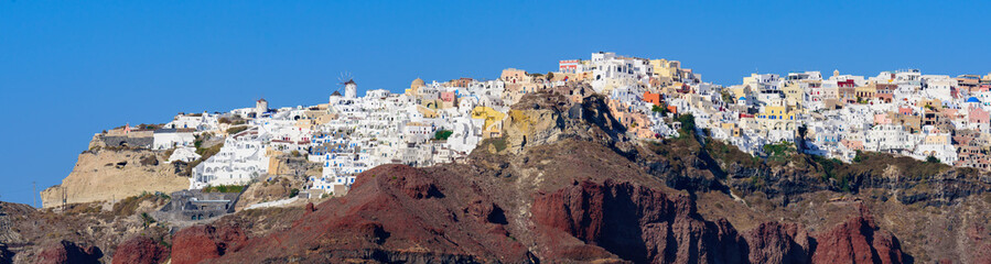 Fototapeta na wymiar View of the white buildings of Oia village from Aegean Sea, Santorini, Greece