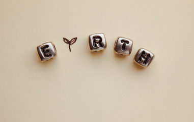 The earth earth is laid out in cubes with letters. Pen. Empty space for text.