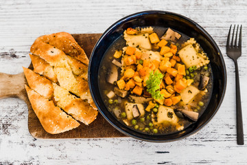 vegan ravioli with vegetable broth peas and pumpkin and side of garlic bread