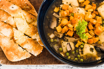 vegan ravioli with vegetable broth peas and pumpkin and side of garlic bread