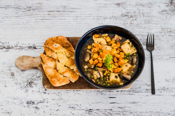 vegan ravioli with vegetable broth peas and pumpkin and side of garlic bread