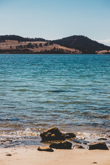 wild Tasmanian landscape and pristine turquoise water of the Derwent River as seen from Legacy Beach