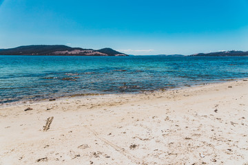 wild Tasmanian landscape and pristine turquoise water of the Derwent River as seen from Legacy Beach near Coningham beach south of Hobart