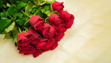 Bunch of beautiful fresh red roses on beige paper 