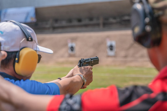 selective focus of man holding and fire hand gun in gun shooting competition