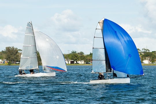 Two sailing dinghies racing at a childrens yachting regatta. Commercial use photo.
