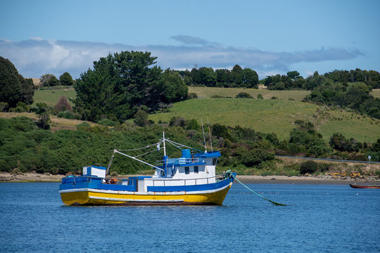Typical Fishing boat on a Bay with meadow hills at background. Chiloe, Chile