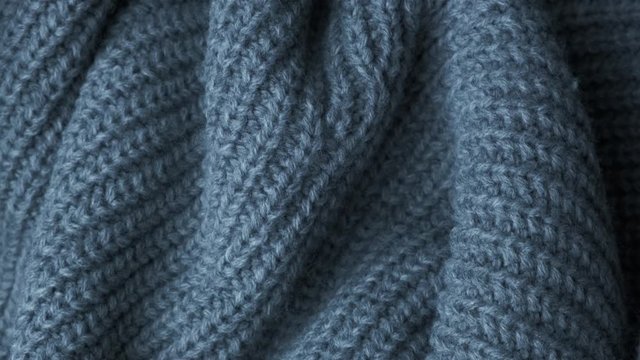 Knitted Wool background. Real Wool clothes texture closeup, dolly shot. Soft grey merino wool macro shoot. Woolen fabric. Knitted texture fabric.