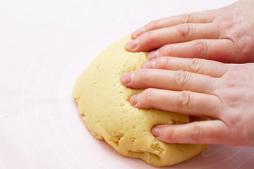 woman preparing dough with hands in the kitchen
