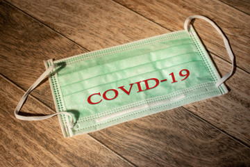 Dramatic atmosphere with surgical mask with COVID-19 text. 2019-nCoV virus infection in Wuhan city. Covid-19 spread around the world. Coronavirus outbreak in China.