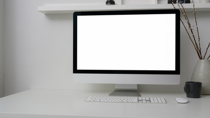 Cropped shot of simple workspace with blank screen computer, decorations and copy space on white table