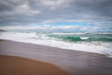 Tropical beach sunset. Empty sand beach and cloudy sky background.