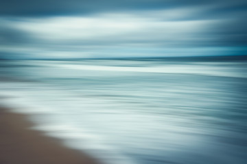 Abstract seascape. Blue hour on the beach. Blurred panning motion, line art, blue colors