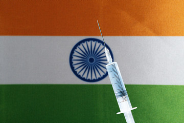 Medical syringe on the background of the flag of India. Copy space
