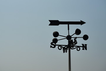 Silhouette of Weather vane against with blue sky in background