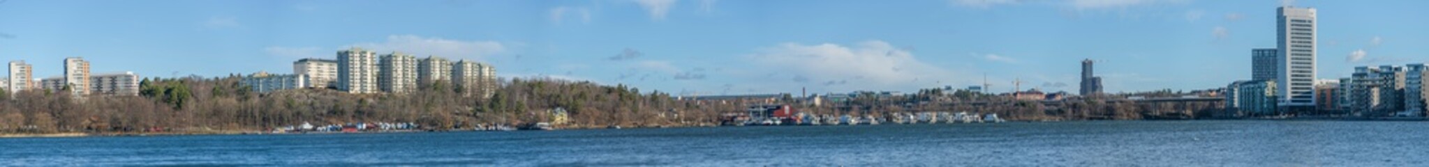 View from the Stockholm district Traneberg over the bay Ulvsundasjön surrounded by the town Solna and the district Kristineberg, jetty, pier and buoys a sunny winter day.