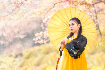 Korean girl wearing a hanbok wearing a yellow umbrella. Beautiful Female wearing traditional Korean...