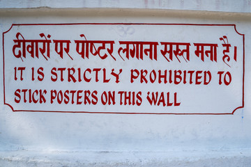 Sign reading It is Strictly Prohibited to Stock Posters on this Wall, in Rishikesh, India