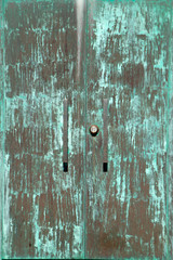 Iron green door in the wall as background and texture.Iron door in the wall as background and texture..