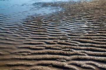 Natural sand patterns in beach at low tide..