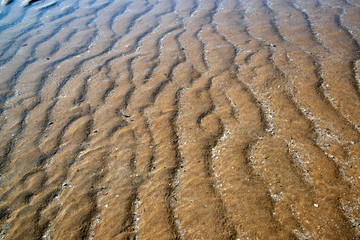 Natural sand patterns in beach at low tide..