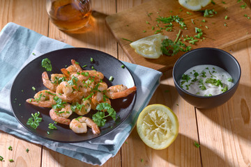 shrimp in a black plate with lemon and green onions