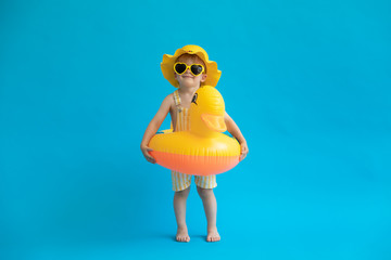 Happy child with yellow rubber duck against blue background