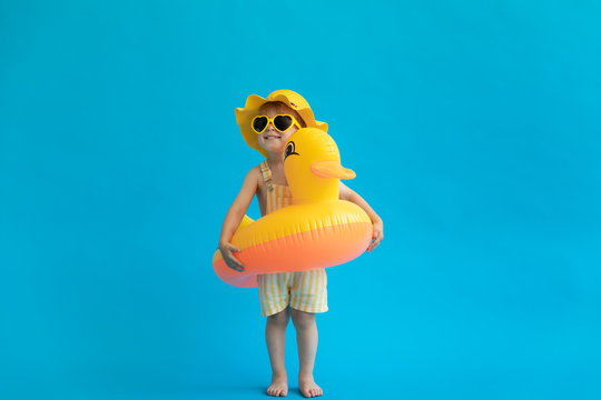 Happy child with yellow rubber duck against blue background
