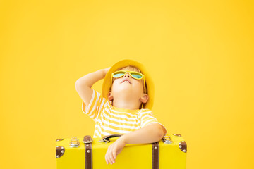 Portrait of happy child with retro yellow suitcase
