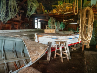 wooden boats and hanged ropes inside in old warehouse in Argentina