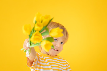 Happy child holding spring bouquet of flowers