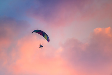 Colorful Paraglider flying against the twilight sky, sunset sky
