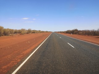 Fototapeta na wymiar Hauptstraße im Outback entlang rotem Sand , Australien